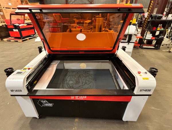 SN4836LR CO2 laser machine with open lid, showcasing the honeycomb cutting table in a workshop setting.